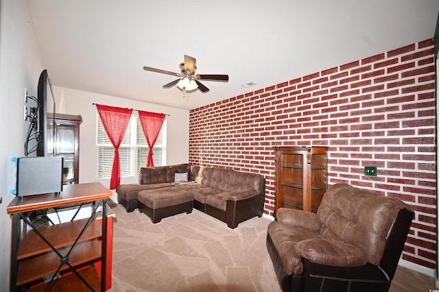 living room with ceiling fan, brick wall, and carpet