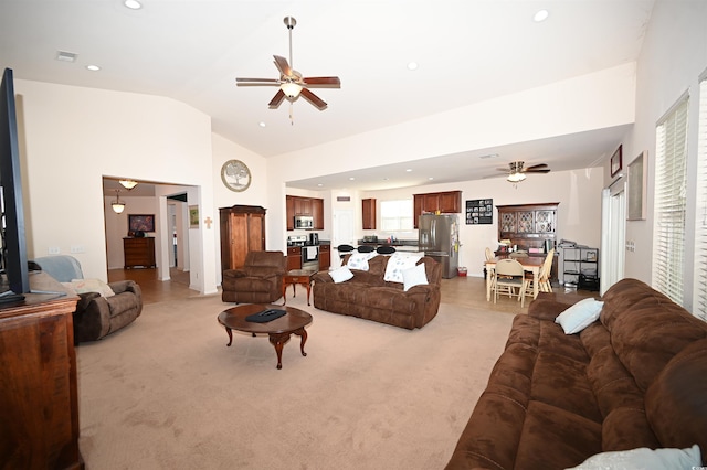 living room with ceiling fan, high vaulted ceiling, and light carpet