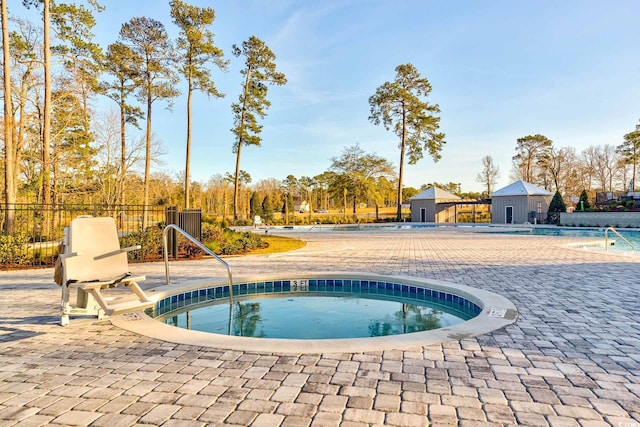 view of swimming pool with a hot tub