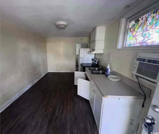 kitchen featuring dark hardwood / wood-style floors, a wall mounted AC, sink, and white cabinets