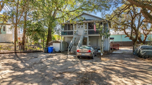 view of front of home with a sunroom and a shed