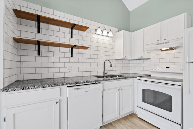 kitchen with white appliances, sink, dark stone countertops, light hardwood / wood-style floors, and white cabinetry