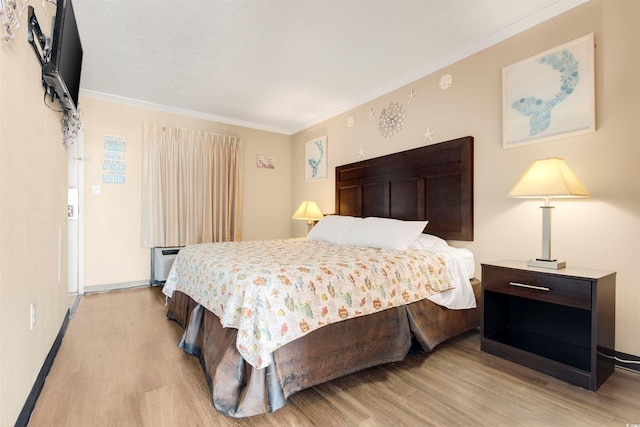 bedroom featuring light hardwood / wood-style floors and crown molding