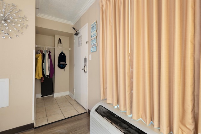 mudroom featuring wood-type flooring, a textured ceiling, and crown molding