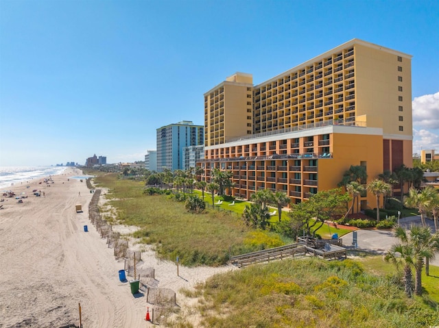 view of building exterior with a water view and a beach view