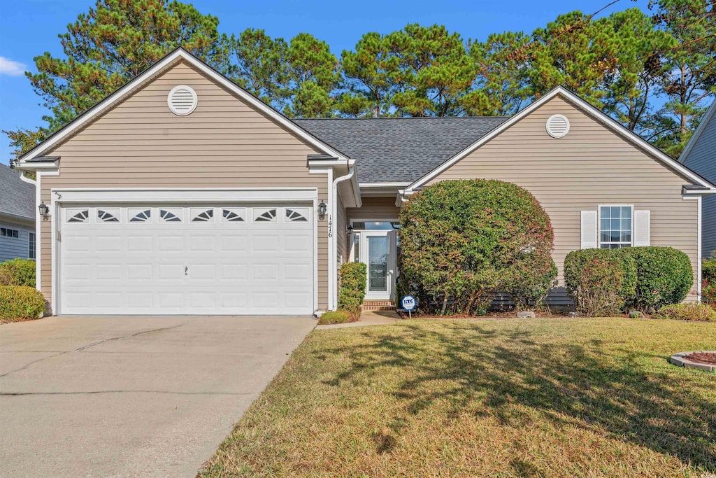 view of front of property featuring a front yard and a garage