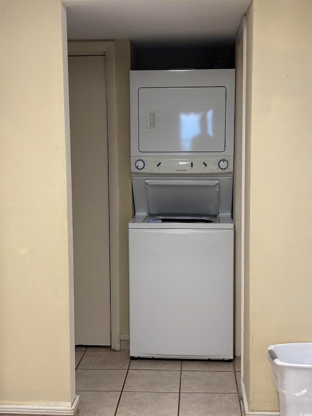 washroom with light tile patterned floors and stacked washer and dryer