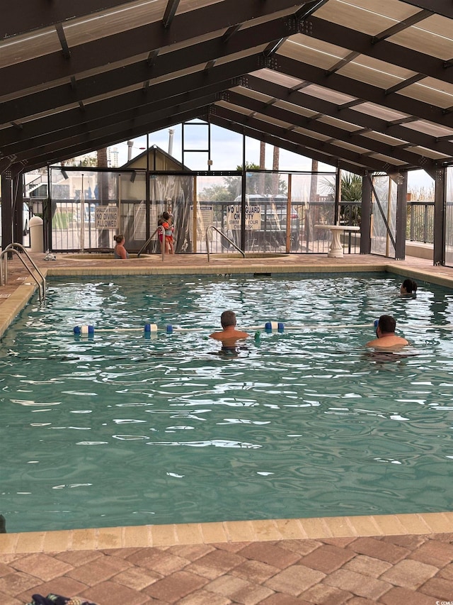 view of swimming pool featuring glass enclosure