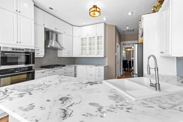 3754 Annandale Dr, Myrtle Beach, SC 29577 - kitchen featuring wall chimney exhaust hood, stainless steel appliances, white cabinets, decorative backsplash, and recessed lighting