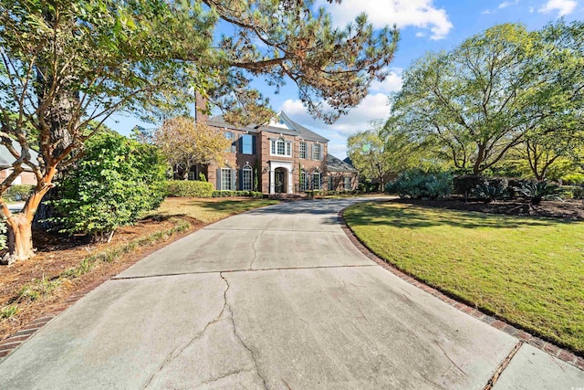 3754 Annandale Dr, Myrtle Beach, SC 29577 - colonial home featuring a front lawn, driveway, brick siding, and a chimney