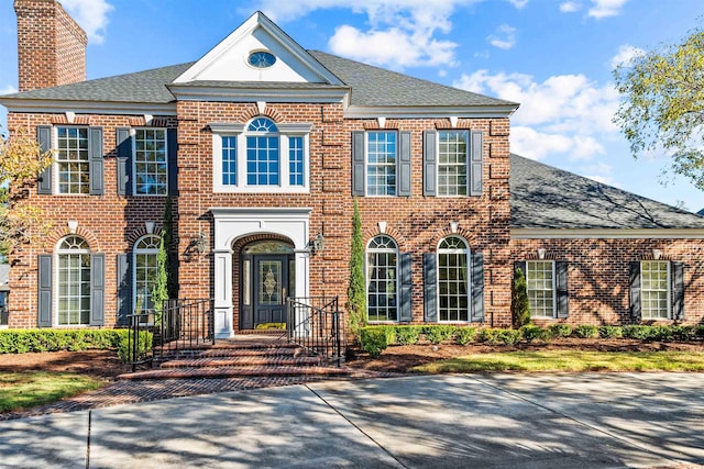 3754 Annandale Dr, Myrtle Beach, SC 29577 - colonial house with brick siding, roof with shingles, and a chimney