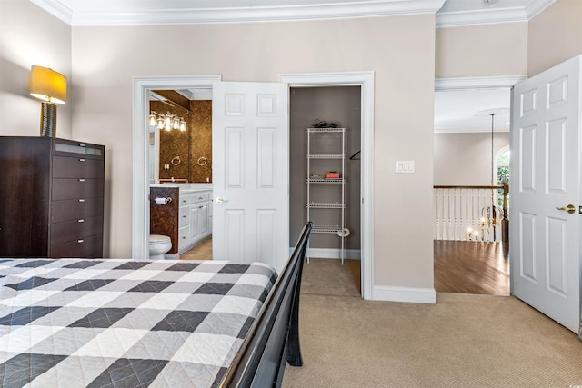 bedroom featuring light carpet, connected bathroom, a closet, and ornamental molding