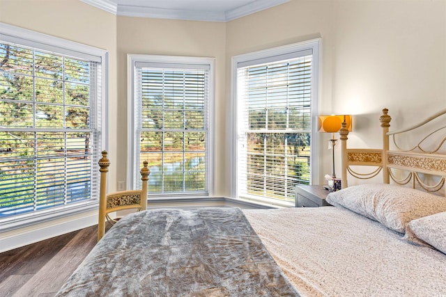 bedroom with multiple windows, ornamental molding, and hardwood / wood-style flooring