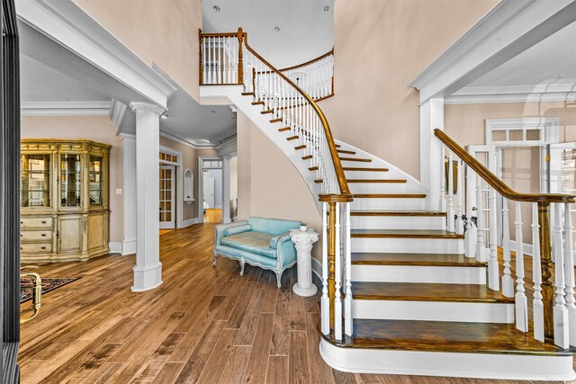 3754 Annandale Dr, Myrtle Beach, SC 29577 - staircase featuring crown molding, wood finished floors, a high ceiling, and decorative columns