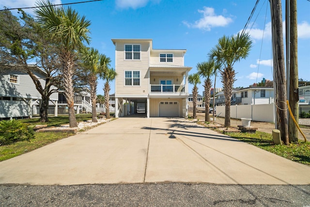 coastal inspired home with a carport, driveway, and fence