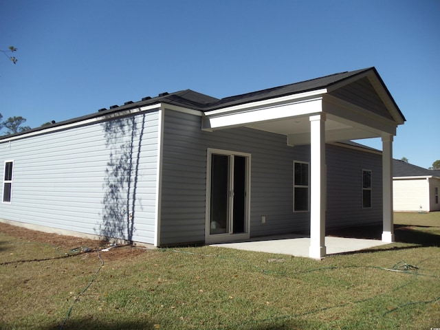 back of property featuring a lawn and a patio area