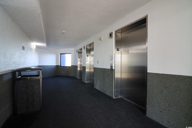 hall featuring elevator and a textured ceiling