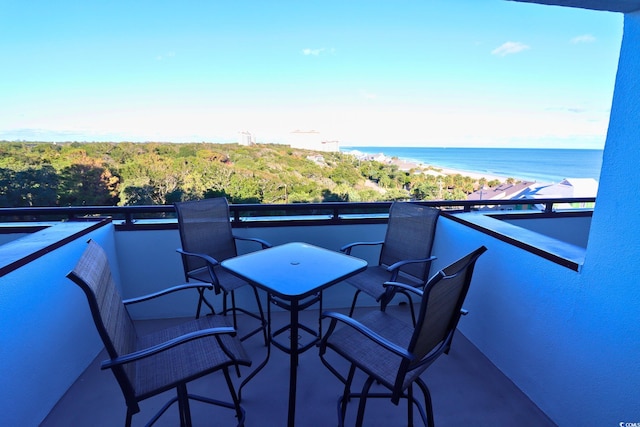 balcony with a water view and a view of the beach