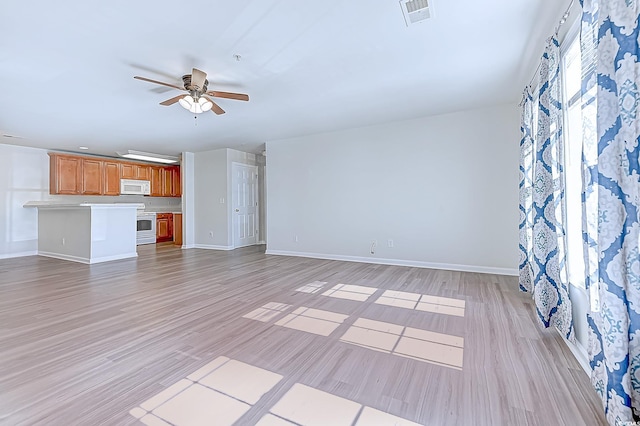 unfurnished living room featuring a ceiling fan, baseboards, visible vents, and light wood finished floors