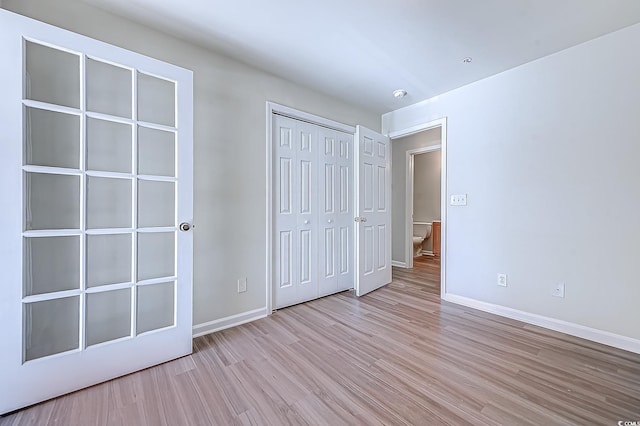 unfurnished bedroom featuring light wood-type flooring and a closet