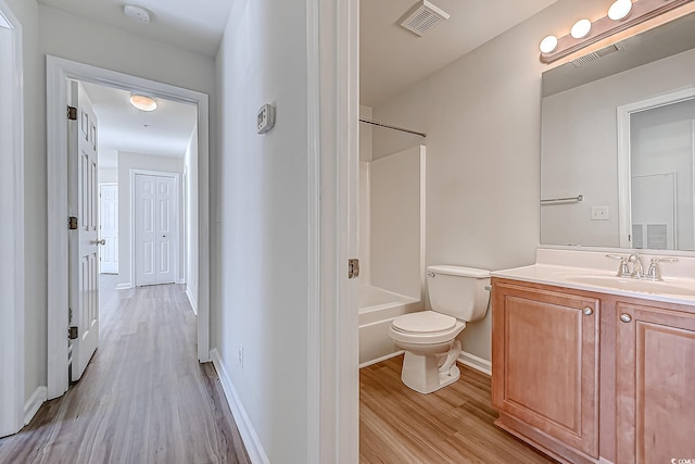 full bathroom featuring vanity, hardwood / wood-style flooring, toilet, and shower / washtub combination