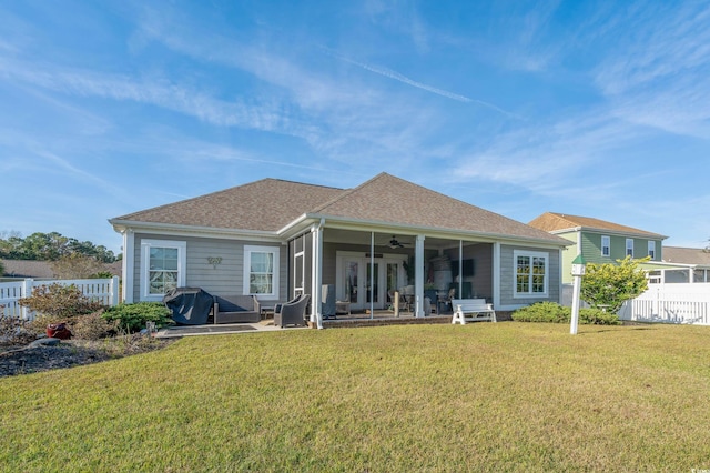 back of property featuring a lawn, a sunroom, and ceiling fan