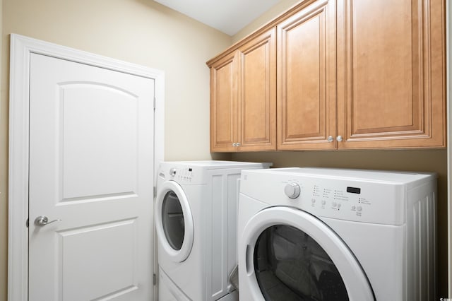 laundry room with cabinets and washing machine and clothes dryer