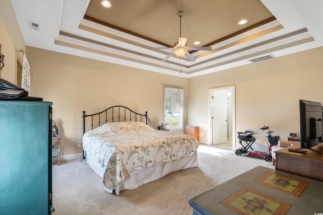 carpeted bedroom featuring ceiling fan, a raised ceiling, ornamental molding, and connected bathroom