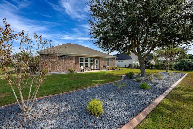 view of front of house with a front yard and a patio area