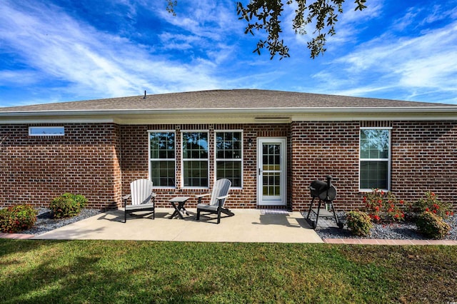 rear view of property featuring a yard and a patio