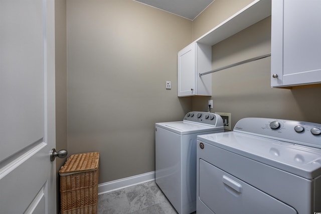 washroom with cabinets and washing machine and clothes dryer