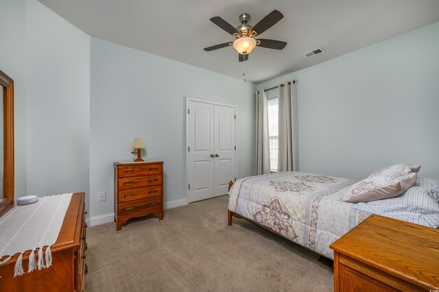 carpeted bedroom with a closet and ceiling fan