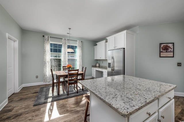 kitchen with white cabinetry, stainless steel fridge with ice dispenser, a kitchen island, and dark wood-type flooring