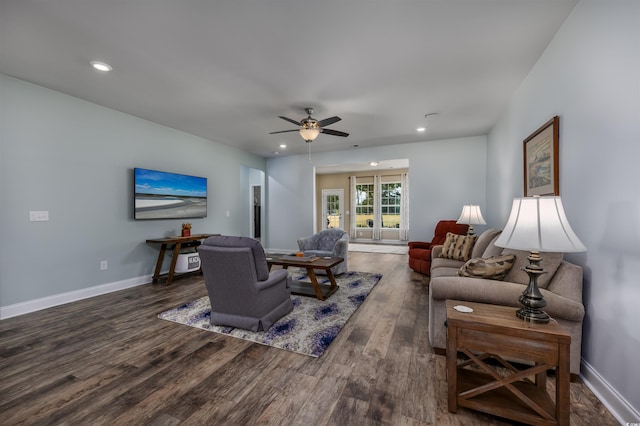 living room featuring ceiling fan and dark wood-type flooring