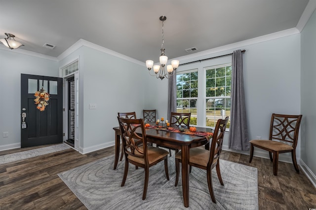 dining space featuring a chandelier, dark hardwood / wood-style flooring, and crown molding