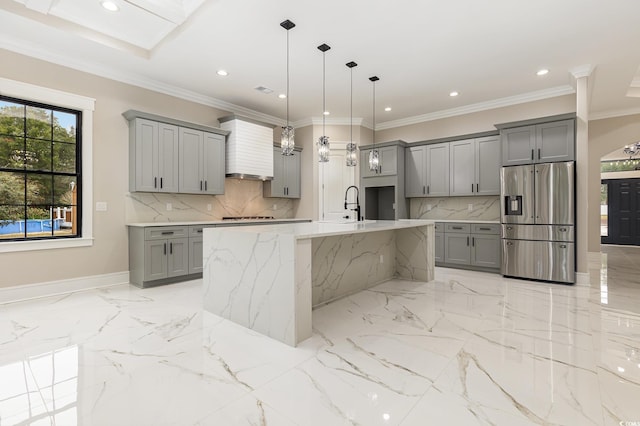 kitchen with stainless steel fridge, crown molding, pendant lighting, gray cabinets, and a kitchen island with sink