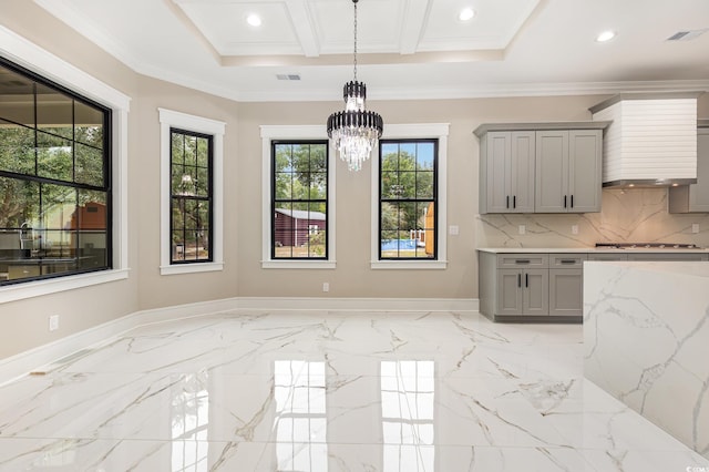 kitchen featuring gray cabinetry, plenty of natural light, stainless steel gas cooktop, and an inviting chandelier