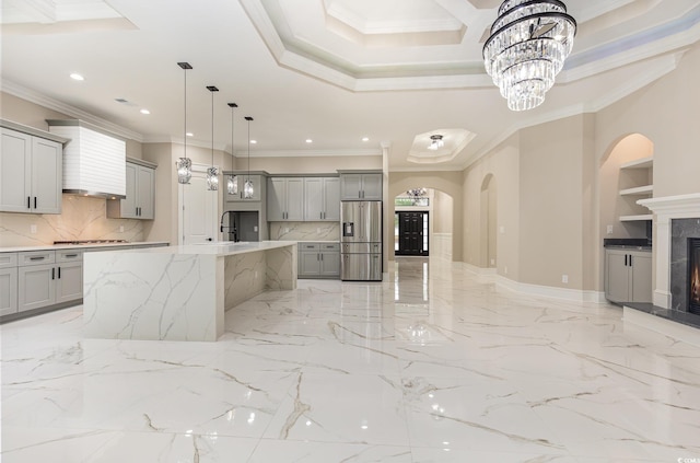 kitchen featuring gray cabinetry, crown molding, an island with sink, and stainless steel appliances