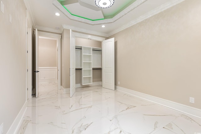 unfurnished bedroom featuring a tray ceiling, a closet, and crown molding