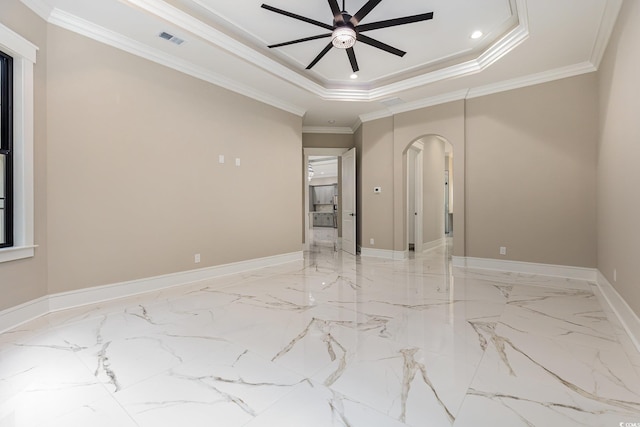 spare room featuring a tray ceiling, crown molding, and ceiling fan