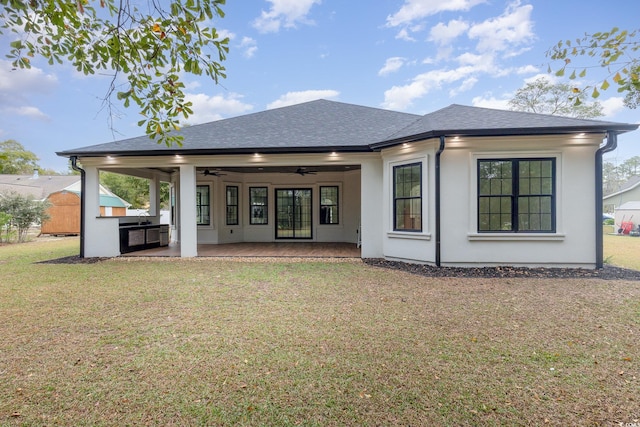 back of property with a lawn, ceiling fan, area for grilling, and a patio