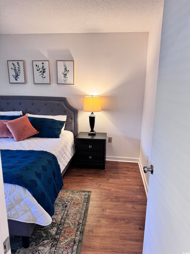 bedroom with hardwood / wood-style flooring and a textured ceiling