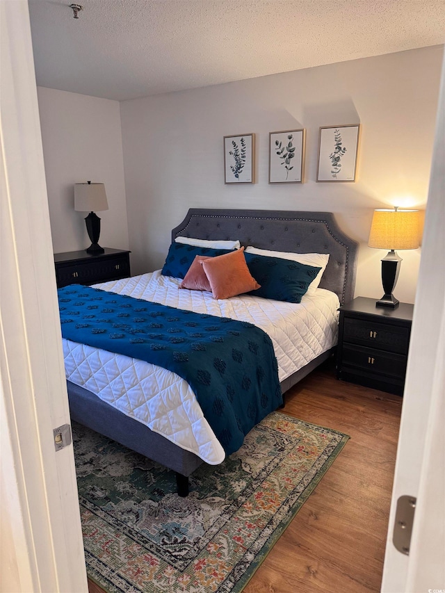 bedroom with wood-type flooring and a textured ceiling