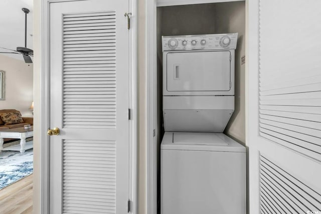 washroom with stacked washer and dryer and light hardwood / wood-style flooring