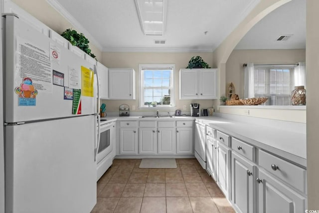 kitchen with white cabinetry, sink, crown molding, and white appliances