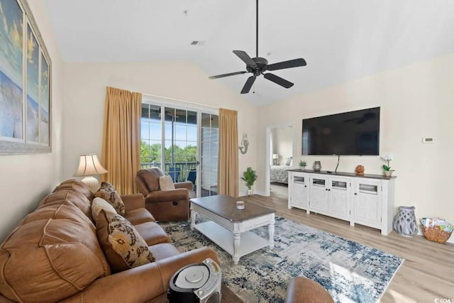 living room featuring ceiling fan, light hardwood / wood-style floors, and vaulted ceiling