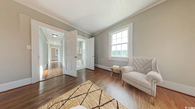 living area featuring crown molding and dark wood-type flooring