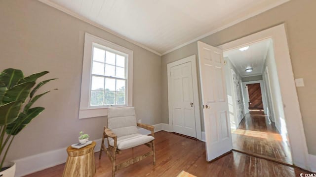 sitting room with hardwood / wood-style flooring and crown molding