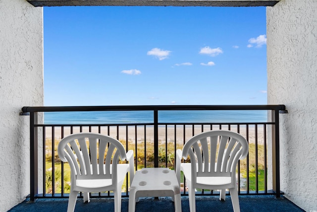 balcony with a water view and a beach view