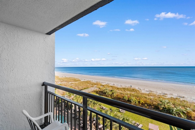 balcony with a water view and a view of the beach